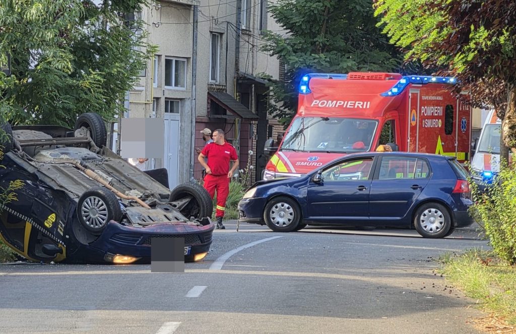 FOTO. Taxi cu roțile în sus, în Satu Mare, după un accident cu o mașină de școală de șoferi!